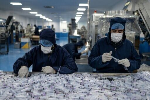Workers assemble and package disposable syringes at the Milli Shifa Pharmaceutical factory on the outskirts of Kabul