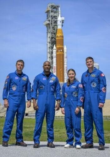 NASA astronauts Reid Wiseman, Victor Glover and Christina Koch and Canadian Space Agency astronaut Jeremy Hansen pose in front of the SLS rocket and Orion spacecraft