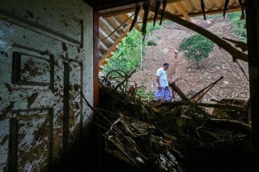 A man walks past a damaged house in Hadabima village on December 4, 2025