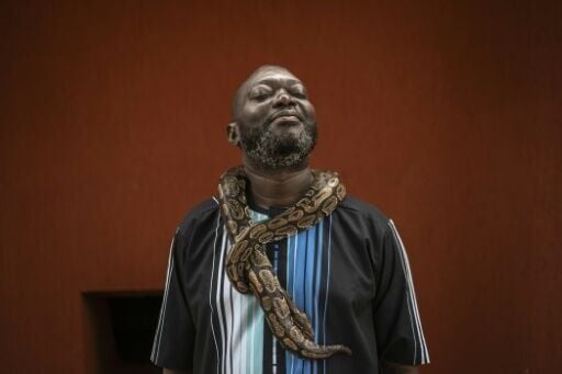 Many pose for photos with snakes draped around their necks