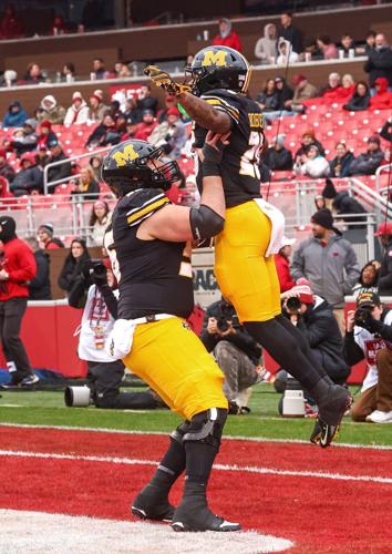 Mizzou offensive guard Dominick Giudice (56) lifts up Mizzou running back Jamal Roberts (20)