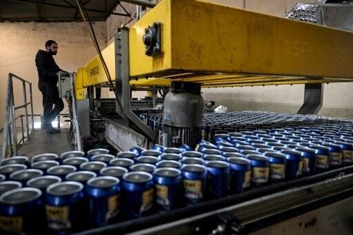 A worker checks beer cans on a production line at Murree Brewery in Rawalpindi