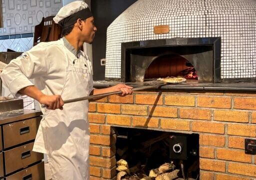 A chef makes pizzas in a wood-fired oven at the Pizza Bakery in Bengaluru