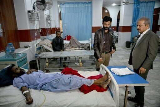 Khalid Bukhari (R), the head of Civil Hospital Karachi, attends a patient
