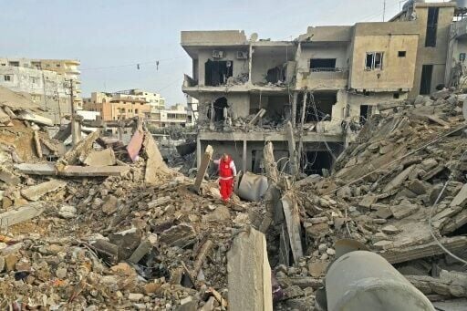 A rescue worker inspects the debris of destroyed buildings in the Maarakeh area near Tyre