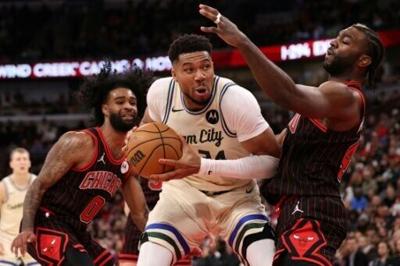 Milwaukee's Giannis Antetokounmpo, center, drives past Chicago's Patrick Williams, right, in the Bucks' NBA victory over the Bulls in the Greek star's return after missing eight games with an injury