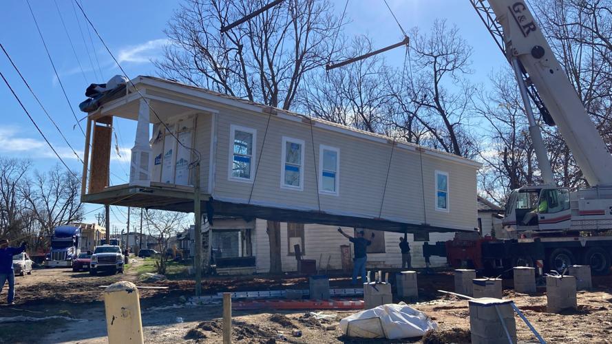 The first NACA home is lifted and set on the foundation pilings