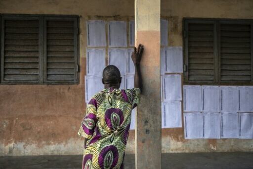 A voter looks for his name on the electoral roll at a primary school serving as a polling station in Cotonou, Benin