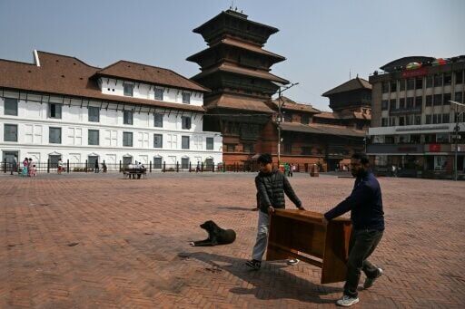 Workers carry a table for a polling booth in Kathmandu. Young Nepali voters say they are hoping for change after last year's protests which toppled the government