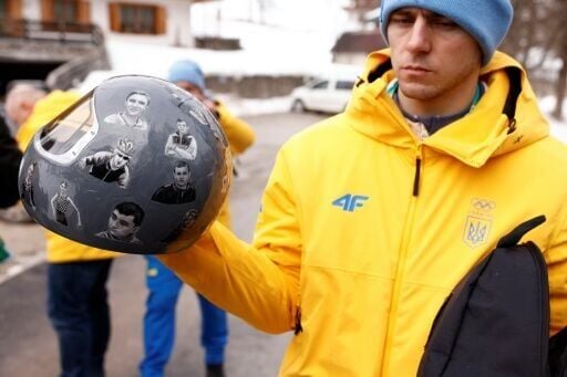 Ukraine's skeleton racer Vladyslav Heraskevych holds his helmet