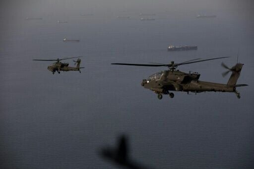 This handout photo released by US Central Command shows AH-64 Apaches flying above the Strait of Hormuz during a patrol on April 17, 2026