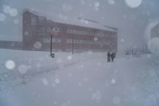 Two people walk through the streets during a snowstorm, in Nuuk, Greenland, on March 21, 2026
