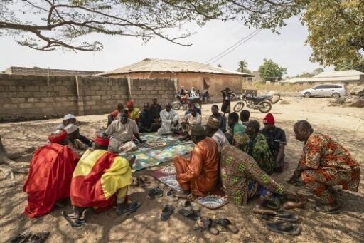 Residents who fled the massacre in the Nigerian village of Woro gather at the local chief's house in the neighbouring town of Kaiama