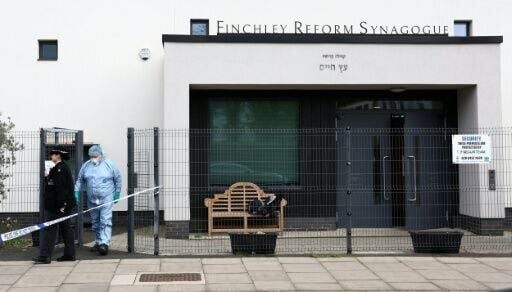 A police forensics officer investigates the scene of one of the attacks, on the Finchley Reform Synagogue