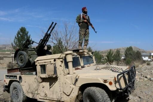 A Taliban security personnel stands guard near an anti-aircraft gun in Khost province bordering Pakistan