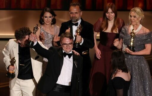 Russian teacher Pavel Talankin (2L) stands alongside US documentary filmmaker David Borenstein (L) as he accepts the Oscar for Best Documentary Feature Film for "Mr. Nobody Against Putin"