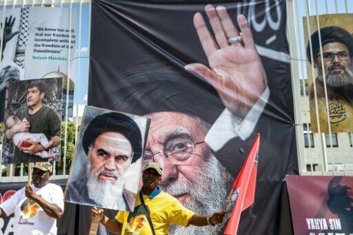 Protesters carry a banner with a portrait of the late Iranian leader Ayatollah Ali Khamenei (C) in Johannesburg