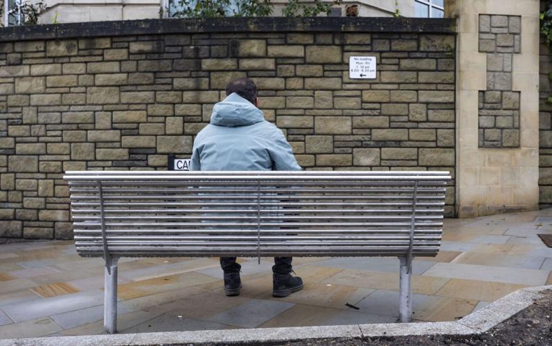 A newly installed bench directly faces a large stone wall