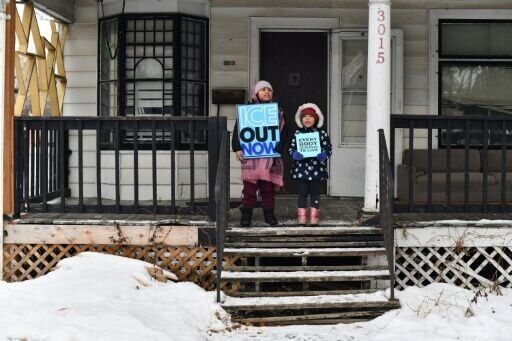 Children hold signs along the route of the protest march in Minneapolis