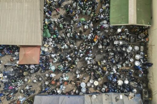 An outdoor kitchen used by Baye Fall followers sends firewood smoke and the aroma of food drifting