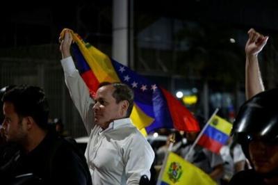 Venezuelan opposition politian leader Juan Pablo Guanipa waves a national flag after his release from Helicoide prison in Caracas on February 8, 2026, before he was detained again