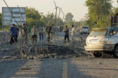 People look at a damaged bridge after Thailand carried out air strikes in an area between Cambodia's Oddar Meanchey and Siem Reap provinces