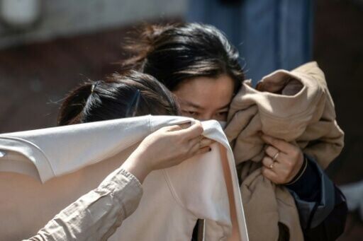 People mourn after identifying bodies in the aftermath of the major fire in Hong Kong's Tai Po district