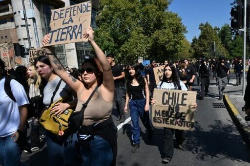 A student holds a sign reading "Chile does not deserve this punishment" during a march against Kast's government