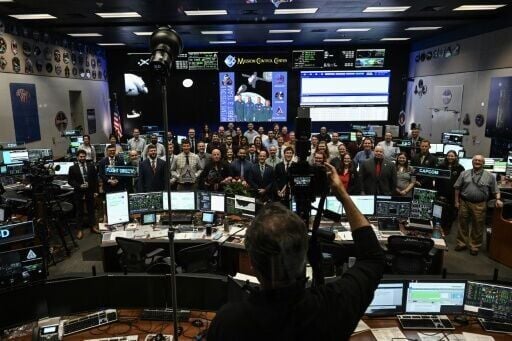 NASA staff pose for a group photo in the White Flight Control Room at Johnson Space Center in Houston, Texas, on April 6, 2026