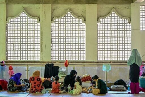 Residents take refuge in a relief camp set up inside a mosque after being evacuated following rapid floods in Gampola on December 4, 2025