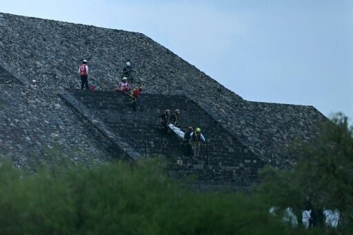 Authorites transport the body of a Canadian woman who was killed by a gunman down the steps of the Pyramid of the Moon following a shooting in Teotihuacan