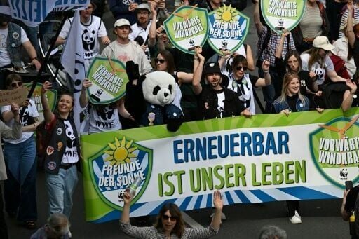 Activists wave a sign reading 'Renewable is our life' at a climate protest in Berlin