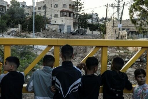 Palestinians waited behind a barrier to retreive their belongings during an Israeli forces raid on the outskirts of the Jenin refugee camp