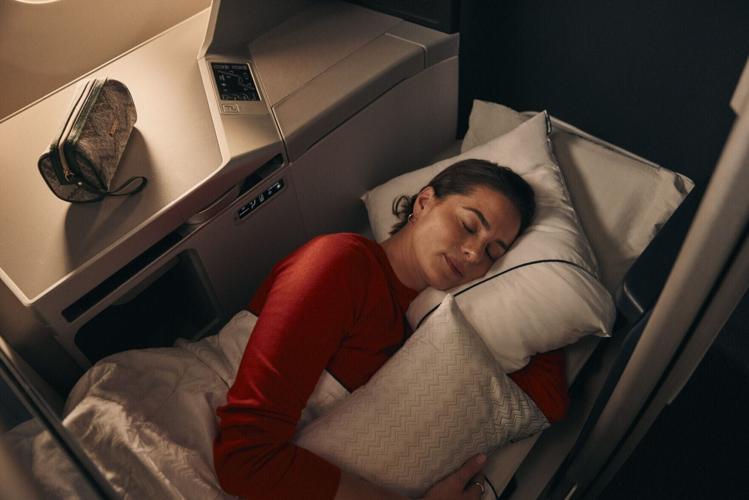 Woman sleeping with Missoni bedding and amenity kit  in Delta One.