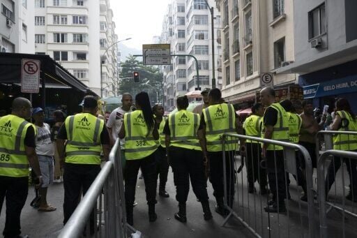 Security personnel check fans as they access streets leading to Copacabana Beach ahead of Shakira's concert