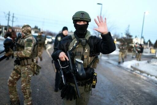 Federal agents monitor the scene as protesters gather near the Bishop Henry Whipple Federal Building in Minneapolis