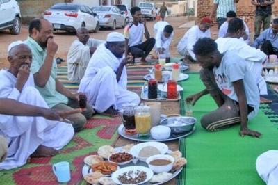 Sudanese people gather to break their fast on the first day of Ramadan