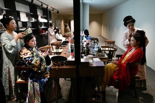 Two women wearing traditional Chinese clothes preparing for their meal at the theatrical restaurant in Beijing