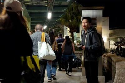 Miles Kwan handing out flyers outside a station in Hong Kong's Tai Po district on November 28 calling for a probe into the deadly fire