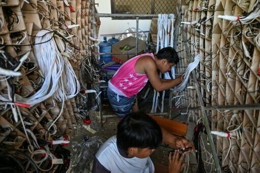 Men working on the intricate wiring of a giant lantern in San Fernando