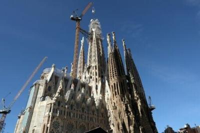 A crane lifts a final piece of a cross atop the Sagrada Familia's Tower of Jesus Christ in Barcelona