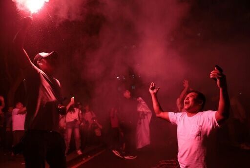 Supporters of Peru's presidential candidate Ricardo Belmont, for the Civico Obras party, react outside the party's headquarters at San Martin square in Lima