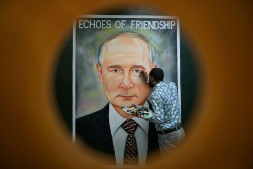An artist gives final touches to a painting of Russia's President Vladimir Putin in Amritsar, ahead of a two-day visit to India
