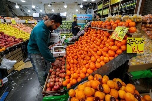 People shop for produce from a grocer's shop in Tehran on March 29, 2026