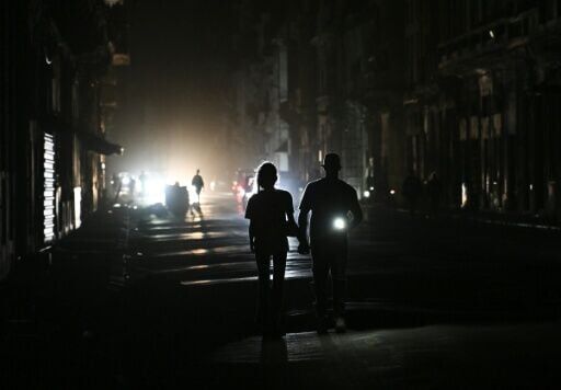 People walk on a street without power during a nationwide blackout in Havana on March 21, 2026