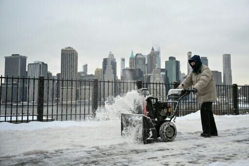 A worker clears snow along the Brooklyn Heights Promenade in New York City, after a monster storm paralyzed much of the US south and northeast