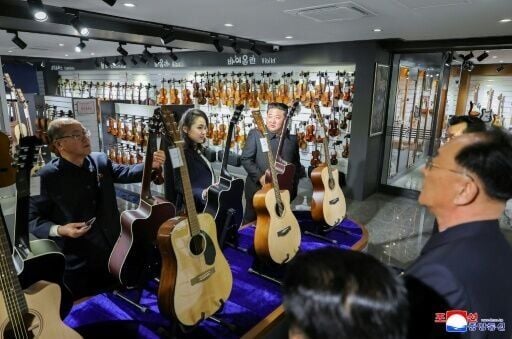 North Korean leader Kim Jong Un (3rd L) and his daughter Kim Ju Ae (2nd L) inspect a musical instrument store awaiting the opening of the fourth-stage district of the Hwasong Area in Pyongyang.