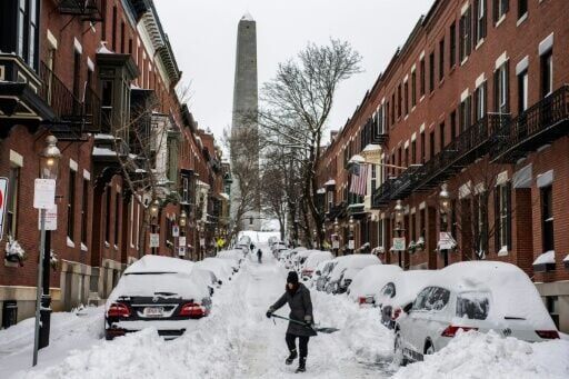 People shovel snow along a residential street in Boston, one of the US cities hit hardest by a colossal storm