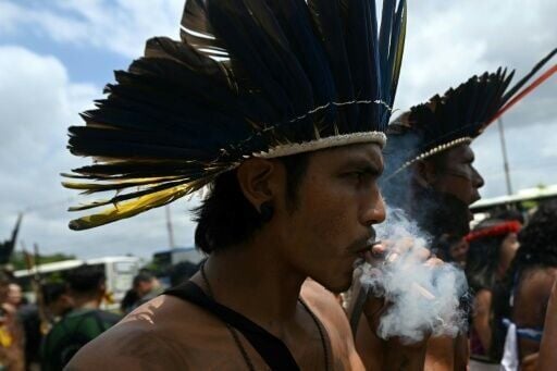 A Munduruku Indigenous man of the Ipereg Ayu movement smokes during a protest outside the COP30 UN Climate Change Conference in Belem