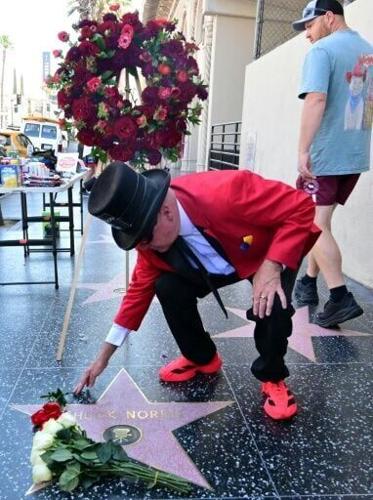 A man leaves flowers on the Hollywood Walk of Fame star of Chuck Norris, awarded in December 1989, following news of the actor and martial arts icon's death